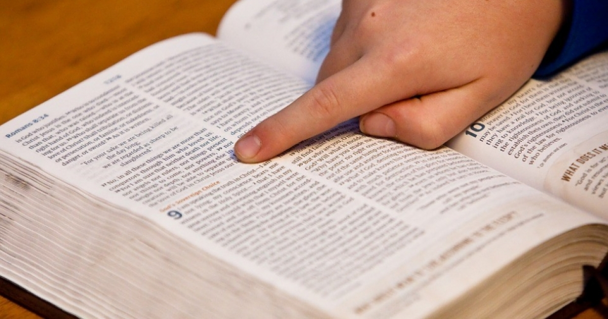 Niño señalando la Biblia (imagen de referencia) © Pixabay